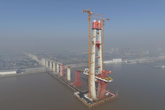 (260116) -- HAIYAN, Jan. 16, 2026 (Xinhua) -- A drone photo taken on Jan. 16, 2026 shows the No. 8 main tower of the northern navigation channel bridge along the Hangzhou Bay Cross-Sea Railway Bridge in east China's Zhejiang Province. The 200-meter-high No. 8 main tower of the northern navigation channel bridge along the Hangzhou Bay Cross-Sea Railway Bridge was topped out on Friday.
   The 29.2-km-long Hangzhou Bay Cross-Sea Railway Bridge, which is a crucial segment of the Nantong-Suzhou-Jiaxing-Ningbo High Speed Railway, consists of three navigation channel bridges and 26-km-long approach bridges, and adopts a ballastless double-track design, with a designed top speed of 350 kilometers per hour. (Xinhua/Huang Zongzhi)