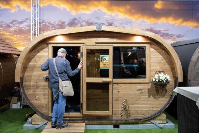 (260116) -- BERLIN, Jan. 16, 2026 (Xinhua) -- A man checks out a sauna hut at the Berlin Green Week in Berlin, Germany, Jan. 16, 2026. This year's Berlin Green Week takes place from January 16 to 25, with more than 1,600 exhibitors presenting food, agriculture and horticulture products. The event marks its 100th anniversary this year. (Xinhua/Zhang Haofu)