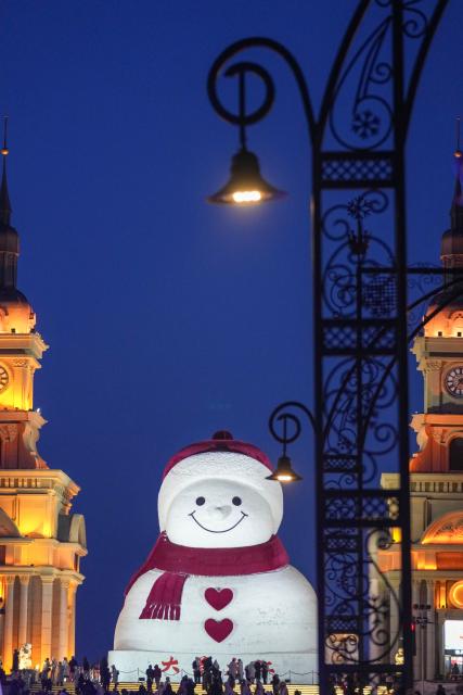 (260117) -- HARBIN, Jan. 17, 2026 (Xinhua) -- Tourists take photos of the iconic giant snowman at the Qunli music park in Harbin, northeast China's Heilongjiang Province, Jan. 10, 2026. With the arrival of the ice and snow season, various public facilities in Heilongjiang Province have created distinctive snowman-themed landscapes to attract locals and tourists. (Xinhua/Wang Jianwei)