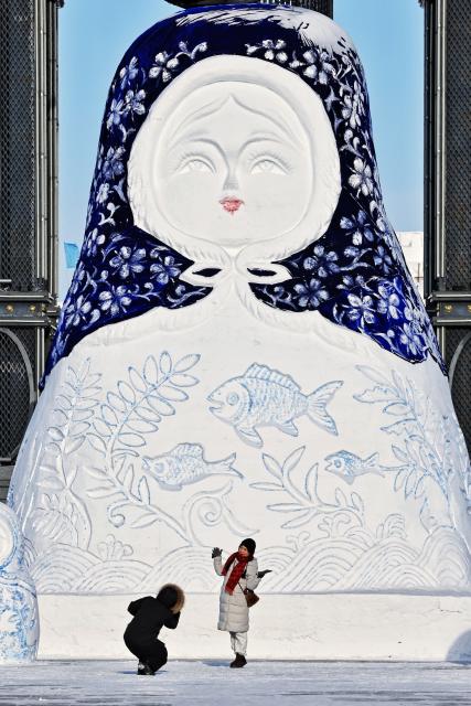 (260117) -- HARBIN, Jan. 17, 2026 (Xinhua) -- A tourist poses for photos in front of a giant snowman in Tongjiang City, northeast China's Heilongjiang Province, Jan. 16, 2026. With the arrival of the ice and snow season, various public facilities in Heilongjiang Province have created distinctive snowman-themed landscapes to attract locals and tourists. (Photo by Liu Wanping/Xinhua)