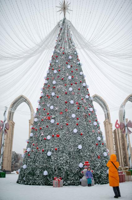 (260117) -- ALMATY, Jan. 17, 2026 (Xinhua) -- People take photos with a snow-covered Christmas tree on a square in downtown Almaty, Kazakhstan, on Jan. 16, 2026. (Xinhua/Li Renzi)