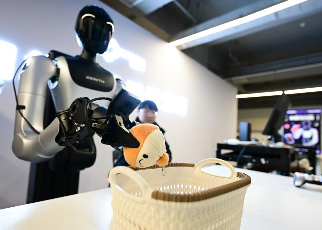 (260117) -- HEFEI, Jan. 17, 2026 (Xinhua) -- A staff member trains a humanoid robot to fetch objects for data collection purpose at Zerith, a robotics company, in Hefei, east China's Anhui Province, Nov. 25, 2025. (Xinhua/Zhou Mu)