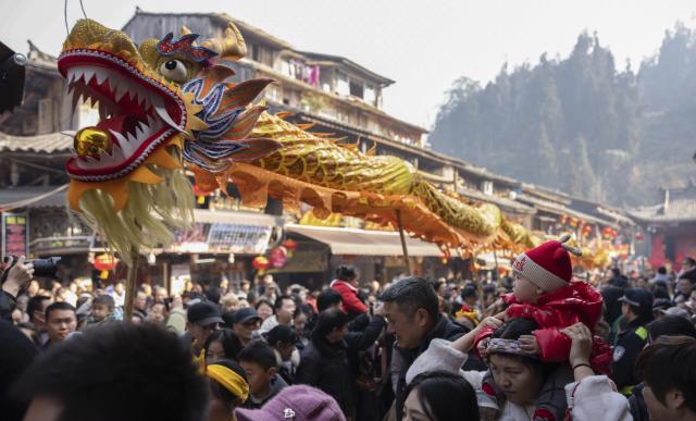 (260117) -- YA'AN, Jan. 17, 2026 (Xinhua) -- Visitors watch a dragon dance during a cultural tourism event at Shangli Ancient Town in Ya'an, southwest China's Sichuan Province, Jan. 17, 2026. (Xinhua/Xu Bingjie)