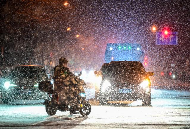 (260117) -- BEIJING, Jan. 17, 2026 (Xinhua) -- People wait at a red light amidst snowfall in Beijing, capital of China, on Jan. 17, 2026. Beijing witnessed a snowfall on Friday. (Xinhua/Chen Yehua)
