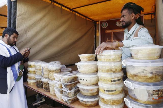 (260118) -- SANAA, Jan. 18, 2026 (Xinhua) -- A honey seller displays a variety of honey products for sale during the annual Yemeni honey festival in Sanaa, Yemen, on Jan. 17, 2026. The annual Yemeni honey festival themed "Yemen, the Home of Honey," was held in Sanaa on Saturday, aiming to uphold its status as one of the nation's most significant products, valued for its nutrition and economic benefits. (Photo by Mohammed Mohammed/Xinhua)