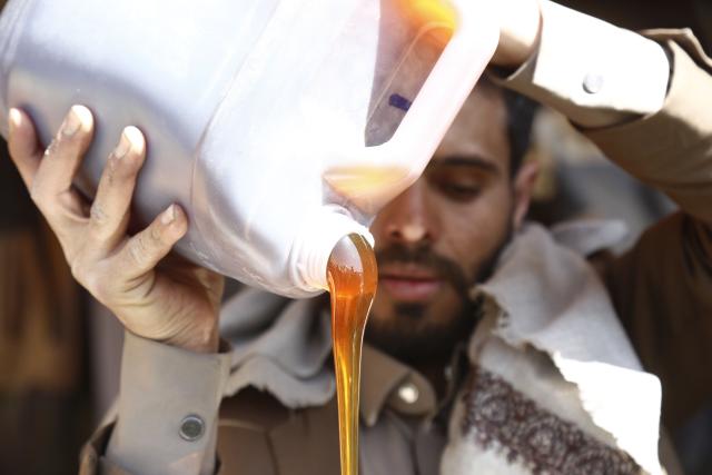 (260118) -- SANAA, Jan. 18, 2026 (Xinhua) -- A seller pours honey into a jerrycan during the annual Yemeni honey festival in Sanaa, Yemen, on Jan. 17, 2026. The annual Yemeni honey festival themed "Yemen, the Home of Honey," was held in Sanaa on Saturday, aiming to uphold its status as one of the nation's most significant products, valued for its nutrition and economic benefits. (Photo by Mohammed Mohammed/Xinhua)