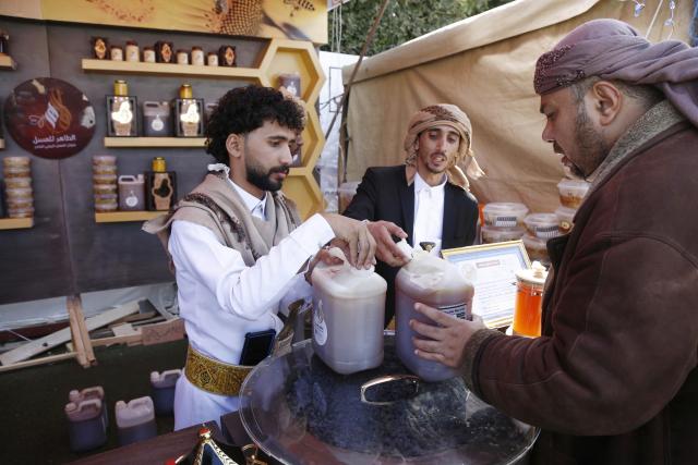 (260118) -- SANAA, Jan. 18, 2026 (Xinhua) -- A customer checks the quality of honey to buy during the annual Yemeni honey festival in Sanaa, Yemen, on Jan. 17, 2026. The annual Yemeni honey festival themed "Yemen, the Home of Honey," was held in Sanaa on Saturday, aiming to uphold its status as one of the nation's most significant products, valued for its nutrition and economic benefits. (Photo by Mohammed Mohammed/Xinhua)