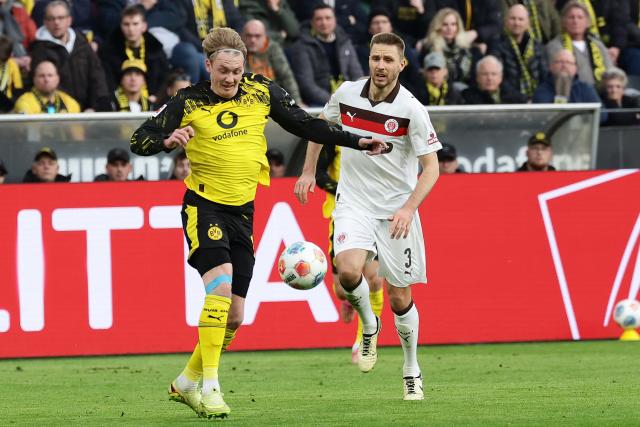 (260118) -- DORTMUND, Jan. 18, 2026 (Xinhua) -- Julian Brandt (L) of Borussia Dortmund vies with Karol Mets of FC St. Pauli during the German first division Bundesliga football match between Borussia Dortmund and FC St. Pauli in Dortmund, Germany, Jan. 17, 2026. (Photo by Joachim Bywaletz/Xinhua)