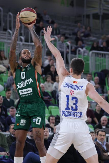 (260118) -- LJUBLJANA, Jan. 18, 2026 (Xinhua) -- Dewayne Stewart JR (L) of Cedevita Olimpija shoots during the 15th round of the ABA Basketball League match between Cedevita Olimpija and Buducnost VOLI in Ljubljana, Slovenia, Jan.17, 2026. (Photo by Zeljko Stevanic/Xinhua)