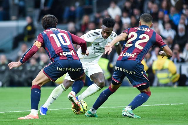 (260118) -- MADRID, Jan. 18, 2026 (Xinhua) -- Real Madrid's Vinicius Junior vies with Levante UD's Pablo Martinez (L) and Jeremy Toljan (R) during the La Liga football match between Real Madrid and Levante UD in Madrid, Spain, on Jan. 17, 2026. (Photo by Gustavo Valiente/Xinhua)