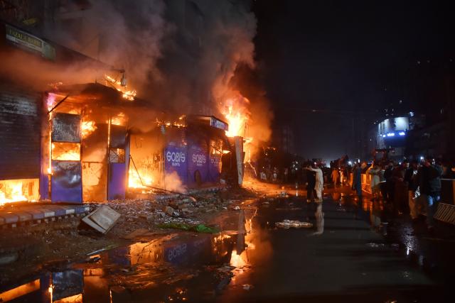 (260118) -- KARACHI, Jan. 18, 2026 (Xinhua) -- Locals and rescuers gather as a fire broke out at a shopping mall in southern Pakistani port city of Karachi on Jan. 18, 2026. At least six people were killed and over 20 others injured after a fire broke out at a shopping mall in Pakistan's southern port city of Karachi late Saturday night, officials said on Sunday.
   Spokesperson of the southern Sindh province, Sadia Javed, told Xinhua that the blaze erupted at Gul Plaza, a multi-storey shopping mall located on the MA Jinnah Road, which houses over 1,200 shops. (Str/Xinhua)