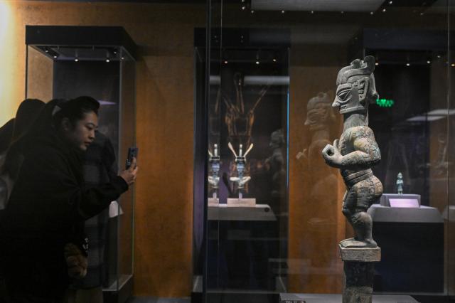 (260118) -- BEIJING, Jan. 18, 2026 (Xinhua) -- A visitor views a bronze standing figure during an exhibition named "Ancient Shu Civilization of the Sanxingdui and Jinsha Sites" at the National Museum of China in Beijing, capital of China, Jan. 18, 2026. With more than 200 pieces (sets) of relics featuring ancient Shu civilization, the exhibition kicked off here on Sunday and will last until Aug. 18. (Xinhua/Jin Liangkuai)