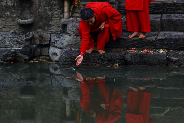 (260118) -- KATHMANDU, Jan. 18, 2026 (Xinhua) -- A devotee performs a ritual during the month-long Madhav Narayan Festival at Pashupatinath Temple in Kathmandu, Nepal, Jan. 18, 2026. The festival is observed through fasting and praying to Goddess Swasthani and God Madhav Narayan. (Photo by Sulav Shrestha/Xinhua)