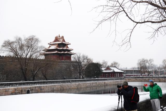 (260118) -- BEIJING, Jan. 18, 2026 (Xinhua) -- People take photos near a turret of the Palace Museum after a snowfall in Beijing, capital of China, Jan. 18, 2026. Beijing witnessed a snowfall this weekend. (Photo by Wang Yuewu/Xinhua)