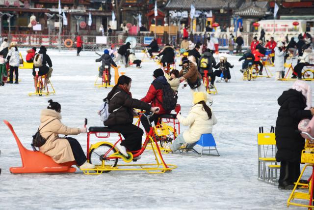 (260118) -- BEIJING, Jan. 18, 2026 (Xinhua) -- People ride sleds on the frozen Shichahai lake in Beijing, capital of China, Jan. 18, 2026. Beijing witnessed a snowfall this weekend. (Photo by Wang Yuewu/Xinhua)