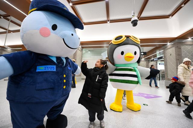 (260118) -- TIANJIN, Jan. 18, 2026 (Xinhua) -- A child interacts with costumed performers at Beitang Station of Tianjin Rail Transit Line Z4 in north China's Tianjin, on Jan. 18, 2026. The northern section of the first phase of Tianjin Rail Transit Line Z4 began operations on Sunday.
   The newly opened section spans 23.7 kilometers with 10 stations. Upon completion, the full Phase 1 line will cover a total length of 43.7 kilometers with 24 stations.
   As a backbone line linking the northern and southern parts of the Binhai New Area with its core district, the Z4 line is expected to play a vital role in optimizing the regional rail system and promoting integration. (Xinhua/Zhao Zishuo)