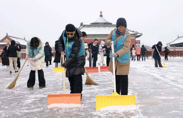 (260118) -- BEIJING, Jan. 18, 2026 (Xinhua) -- Staff members clear the snow at the Tiantan Park (Temple of Heaven) after a snowfall in Beijing, capital of China, Jan. 18, 2026. Beijing witnessed a snowfall this weekend. (Photo by Zhang Jiang/Xinhua)