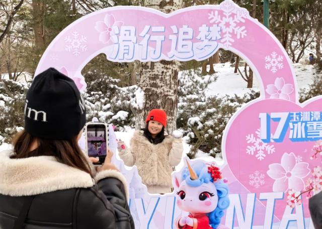 (260118) -- BEIJING, Jan. 18, 2026 (Xinhua) -- A tourist poses for photos at the Yuyuantan Park after a snowfall in Beijing, capital of China, Jan. 18, 2026. Beijing witnessed a snowfall this weekend. (Photo by Xia Ran/Xinhua)
