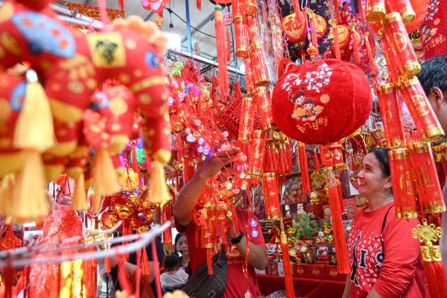 (260118) -- JAKARTA, Jan. 18, 2026 (Xinhua) -- People choose Chinese New Year decorations at a street stall in Glodok Chinatown of Jakarta, Indonesia, Jan. 18, 2026. (Photo by Agung Kuncahya B./Xinhua)