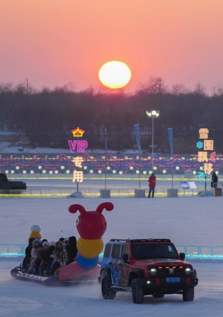 (260118) -- HARBIN, Jan. 18, 2026 (Xinhua) -- Tourists have fun at sunset at the Harbin Ice-Snow World, the world's largest ice-and-snow theme park, in Harbin, northeast China's Heilongjiang Province, Jan. 18, 2026. (Xinhua/Wang Jianwei)