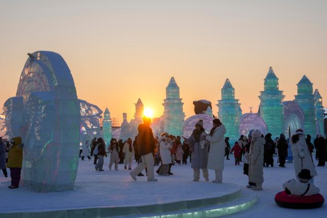 (260118) -- HARBIN, Jan. 18, 2026 (Xinhua) -- Tourists have fun at sunset at the Harbin Ice-Snow World, the world's largest ice-and-snow theme park, in Harbin, northeast China's Heilongjiang Province, Jan. 18, 2026. (Xinhua/Wang Jianwei)