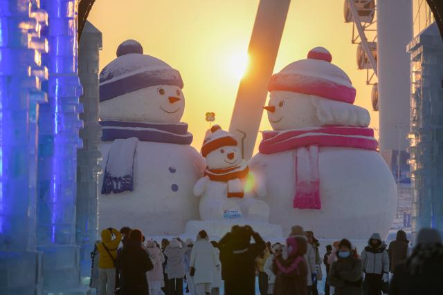 (260118) -- HARBIN, Jan. 18, 2026 (Xinhua) -- Tourists have fun at sunset at the Harbin Ice-Snow World, the world's largest ice-and-snow theme park, in Harbin, northeast China's Heilongjiang Province, Jan. 18, 2026. (Xinhua/Wang Jianwei)