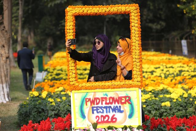 (260118) -- DHAKA, Jan. 18, 2026 (Xinhua) -- Visitors take selfies among blooming flowers at Ramna Park in Dhaka, Bangladesh, Jan. 18, 2026. (Photo by Habibur Rahman/Xinhua)
