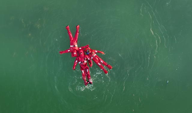 (260118) -- YINCHUAN, Jan. 18, 2026 (Xinhua) -- An aerial drone photo shows people in crayfish costumes experiencing floating on the water at a park in Yinchuan, northwest China's Ningxia Hui Autonomous Region, Jan. 17, 2026. (Xinhua/Wang Peng)