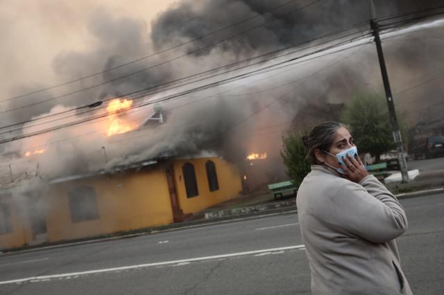 (260118) -- SANTIAGO, Jan. 18, 2026 (Xinhua) -- A woman stands in front of a building affected by a forest fire in Penco, Biobio region, Chile, Jan. 18, 2026. Chilean President Gabriel Boric announced a state of catastrophe in the regions of Nuble and Biobio on Sunday after forest fires killed at least 16 people.
   "Given the serious fires currently underway, I have decided to declare a state of catastrophe in the regions of Nuble and Biobio. All resources are available," Boric said in a post on social media X. (Xinhua)