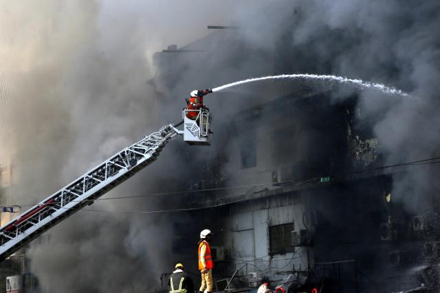 (260119) -- KARACHI, Jan. 19, 2026 (Xinhua) -- Firefighters try to extinguish a fire breaking out at a shopping mall in Karachi, Pakistan, on Jan. 18, 2026. The death toll from a fire at a shopping mall in Pakistan's southern port city of Karachi rose to 14 on Monday morning after rescue teams recovered more bodies during a search operation, officials said. (Xinhua)