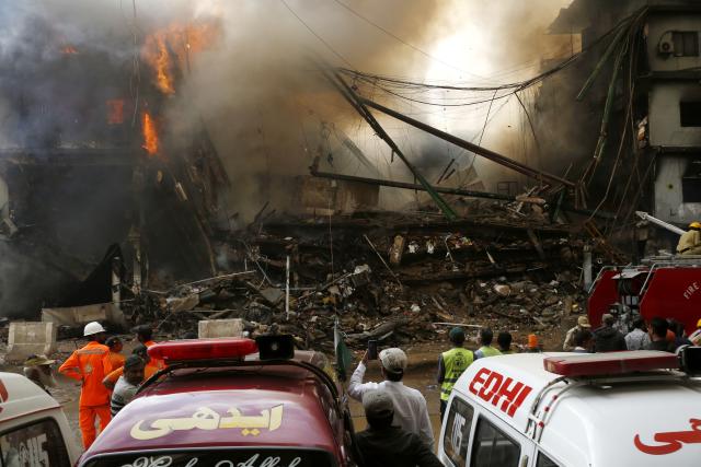 (260119) -- KARACHI, Jan. 19, 2026 (Xinhua) -- People gather near a fire breaking out at a shopping mall in Karachi, Pakistan, on Jan. 18, 2026. The death toll from a fire at a shopping mall in Pakistan's southern port city of Karachi rose to 14 on Monday morning after rescue teams recovered more bodies during a search operation, officials said. (Xinhua)