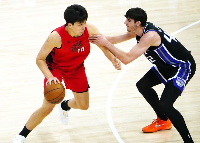 (260119) -- SACRAMENTO, Jan. 19, 2026 (Xinhua) -- Portland Trail Blazers' Yang Hansen (L) vies with Sacramento Kings' Maxime Raynaud during the 2025-2026 NBA regular season basketball game between Portland Trail Blazers and Sacramento Kings in Sacramento, the United States, Jan. 18, 2026. (Xinhua/Wu Xiaoling)