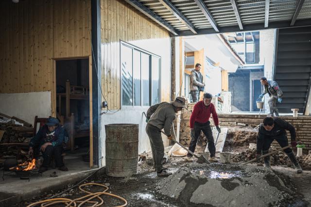 (260119) -- LIJIANG, Jan. 19, 2026 (Xinhua) -- People work at the construction site of a homestay in Yuhu Village, Lijiang City, southwest China's Yunnan Province, Jan. 17, 2026. Yuhu Village, nestled in Baisha Township of Yulong Naxi Autonomous County in the city of Lijiang in Yunnan, is one of the earliest settlements of the Naxi ethnic people. The village was once among the poorest villages in Lijiang because of its poor soil and limited transportation links.   
  In recent years, Yuhu has developed a distinct path that balances economic growth with environmental protection. Leveraging its well-preserved Naxi cultural heritage and exceptional natural scenery, the village has attracted visitors from around the world. At the same time, it has continued to improve infrastructure and public services, attracting a growing number of residents to return home for businesses.  
  In 2025, Yuhu Village welcomed about 1.2 million visits, generating 75 million yuan (10.8 million U.S. dollars) in revenue -- with the average income of locals increasing from 13,000 yuan (1,865 U.S. dollars) in 2019 to about 35,000 yuan (5,022 U.S. dollars). (Xinhua/Wang Guansen)