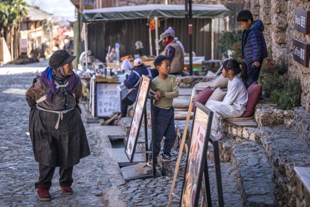 (260119) -- LIJIANG, Jan. 19, 2026 (Xinhua) -- A senior citizen walks in Yuhu Village, Lijiang City, southwest China's Yunnan Province, Jan. 17, 2026. Yuhu Village, nestled in Baisha Township of Yulong Naxi Autonomous County in the city of Lijiang in Yunnan, is one of the earliest settlements of the Naxi ethnic people. The village was once among the poorest villages in Lijiang because of its poor soil and limited transportation links.   
  In recent years, Yuhu has developed a distinct path that balances economic growth with environmental protection. Leveraging its well-preserved Naxi cultural heritage and exceptional natural scenery, the village has attracted visitors from around the world. At the same time, it has continued to improve infrastructure and public services, attracting a growing number of residents to return home for businesses.  
  In 2025, Yuhu Village welcomed about 1.2 million visits, generating 75 million yuan (10.8 million U.S. dollars) in revenue -- with the average income of locals increasing from 13,000 yuan (1,865 U.S. dollars) in 2019 to about 35,000 yuan (5,022 U.S. dollars). (Xinhua/Wang Guansen)