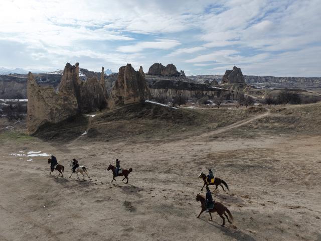 (260119) -- CAPPADOCIA, Jan. 19, 2026 (Xinhua) -- Tourists ride horses among the unique fairy chimneys rocks in Cappadocia, Türkiye, Jan. 16, 2026. (Photo by Mustafa Kaya/Xinhua)