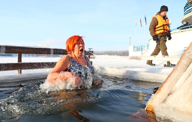 (260119) -- MINSK, Jan. 19, 2026 (Xinhua) -- A woman takes a dip in the icy water during the Orthodox Epiphany celebrations in Minsk, Belarus, Jan. 19, 2026. (Photo by Henadz Zhinkov/Xinhua)