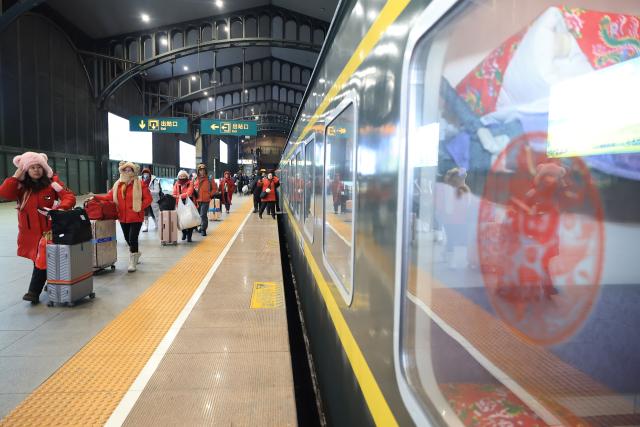 (260119) -- HARBIN, Jan. 19, 2026 (Xinhua) -- Foreign tourists board K7041, a train themed on folk culture of northeast China, at Harbin Railway Station in Harbin, northeast China's Heilongjiang Province, Jan. 19, 2026. Recently, tourists from Southeast Asian countries have been flocking to Harbin, hailed as China's "Ice City," with unprecedented enthusiasm. (Photo by Xu Shuai/Xinhua)