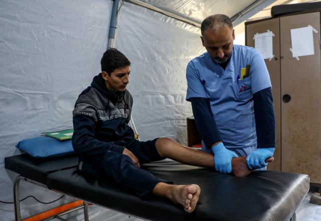 (260119) -- GAZA, Jan. 19, 2026 (Xinhua) -- A medical worker provides treatment for an injured Palestinian man in Gaza City, Jan. 19, 2026. (Photo by Rizek Abdeljawad/Xinhua)