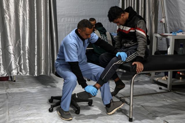 (260119) -- GAZA, Jan. 19, 2026 (Xinhua) -- A medical worker provides treatment for an injured Palestinian man in Gaza City, Jan. 19, 2026. (Photo by Rizek Abdeljawad/Xinhua)