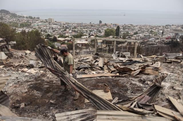 (260119) -- PENCO, Jan. 19, 2026 (Xinhua) -- Residents clean a fire-affected area in Penco, Biobio region, Chile, Jan. 19, 2026. Chilean President Gabriel Boric has declared a state of catastrophe in the regions of Nuble and Biobio to address the emergency. (Str/Xinhua)