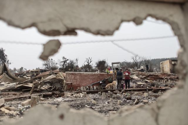 (260120) -- BEIJING, Jan. 20, 2026 (Xinhua) -- Residents clean a fire-affected area in Penco, Biobio region, Chile, Jan. 19, 2026. Chilean President Gabriel Boric has declared a state of catastrophe in the regions of Nuble and Biobio to address the emergency. (Str/Xinhua)