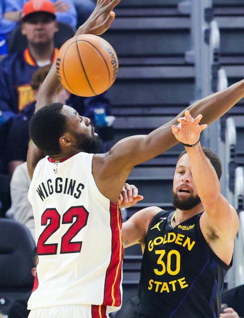 (260120) -- SAN FRANCISCO, Jan. 20, 2026 (Xinhua) -- Golden State Warriors' Stephen Curry (R) passes the ball against Miami Heat's Andrew Wiggins during the 2025-2026 NBA regular season basketball game between Golden State Warriors and Miami Heat in San Francisco, the United States, Jan. 19, 2026. (Photo by Arthur Dong/Xinhua)
