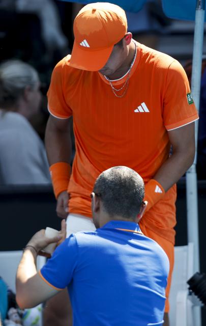 (260120) -- MELBOURNE, Jan. 20, 2026 (Xinhua) -- Wu Yibing of China gets medical treatment during the men's singles 1st round match against Luca Nardi of Italy at the Australian Open tennis tournament in Melbourne, Australia, Jan. 20, 2026. (Xinhua/Ma Ping)