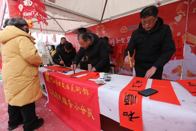 (260120) -- DINGXI, Jan. 20, 2026 (Xinhua) -- Chinese calligraphy enthusiasts write Spring Festival couplets for people at a Spring Festival shopping market in Anding District of Dingxi City, northwest China's Gansu Province, Jan. 19, 2026. The Spring Festival shopping market opened its doors at the potato trading center in Anding District of Dingxi City on Monday and will run until Chinese Lunar New Year's Eve. 
   The marketplace drew tens of thousands of visitors on the opening day, with agricultural specialties, local delicacies, children's entertainment, Qinqiang opera performances, and intangible cultural heritage experiences. There were also hundreds of social media influencers broadcasting the bustling market via live-streaming, and collaborating with on-site vendors to promote local high-quality agricultural products, in an effort to activate holiday consumption potential. (Photo by Wang Kexian/Xinhua)