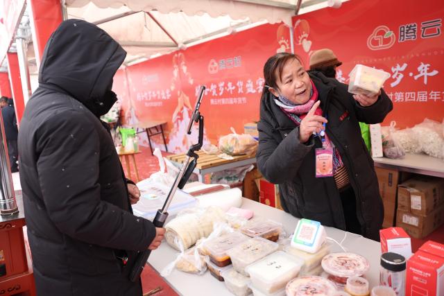 (260120) -- DINGXI, Jan. 20, 2026 (Xinhua) -- A vendor promotes products via live-streaming at a Spring Festival shopping market in Anding District of Dingxi City, northwest China's Gansu Province, Jan. 19, 2026. The Spring Festival shopping market opened its doors at the potato trading center in Anding District of Dingxi City on Monday and will run until Chinese Lunar New Year's Eve. 
   The marketplace drew tens of thousands of visitors on the opening day, with agricultural specialties, local delicacies, children's entertainment, Qinqiang opera performances, and intangible cultural heritage experiences. There were also hundreds of social media influencers broadcasting the bustling market via live-streaming, and collaborating with on-site vendors to promote local high-quality agricultural products, in an effort to activate holiday consumption potential. (Xinhua/Chen Bin)