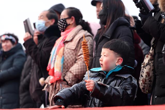(260120) -- DINGXI, Jan. 20, 2026 (Xinhua) -- People watch a performance at a Spring Festival shopping market in Anding District of Dingxi City, northwest China's Gansu Province, Jan. 19, 2026. The Spring Festival shopping market opened its doors at the potato trading center in Anding District of Dingxi City on Monday and will run until Chinese Lunar New Year's Eve. 
   The marketplace drew tens of thousands of visitors on the opening day, with agricultural specialties, local delicacies, children's entertainment, Qinqiang opera performances, and intangible cultural heritage experiences. There were also hundreds of social media influencers broadcasting the bustling market via live-streaming, and collaborating with on-site vendors to promote local high-quality agricultural products, in an effort to activate holiday consumption potential. (Xinhua/Chen Bin)