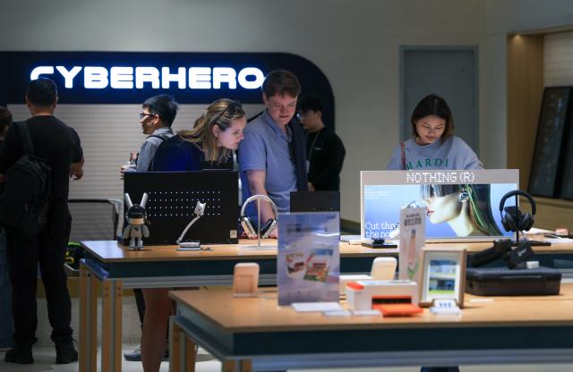 (260120) -- SHENZHEN, Jan. 20, 2026 (Xinhua) -- Customers experience electronic products at the inno100 flagship store in Nanshan District of Shenzhen, south China's Guangdong Province, Jan. 5, 2026. Recently, a number of retail stores in tech sector opened in many business districts of Shenzhen. In theses tech stores, consumers can experience smart electronic products such as embodied intelligent robots, 3D printing, and smart glasses. Shenzhen, a city at the forefront of China's intelligent manufacturing, is creating new scenarios of immersive retail consumption, bringing cutting-edge technology to consumers. (Xinhua/Mao Siqian)