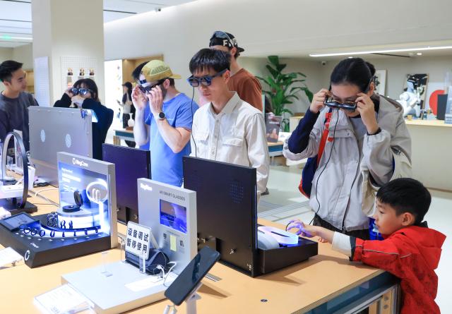 (260120) -- SHENZHEN, Jan. 20, 2026 (Xinhua) -- Customers experience smart glasses at the inno100 flagship store in Nanshan District of Shenzhen, south China's Guangdong Province, Jan. 18, 2026. Recently, a number of retail stores in tech sector opened in many business districts of Shenzhen. In theses tech stores, consumers can experience smart electronic products such as embodied intelligent robots, 3D printing, and smart glasses. Shenzhen, a city at the forefront of China's intelligent manufacturing, is creating new scenarios of immersive retail consumption, bringing cutting-edge technology to consumers. (Xinhua/Mao Siqian)