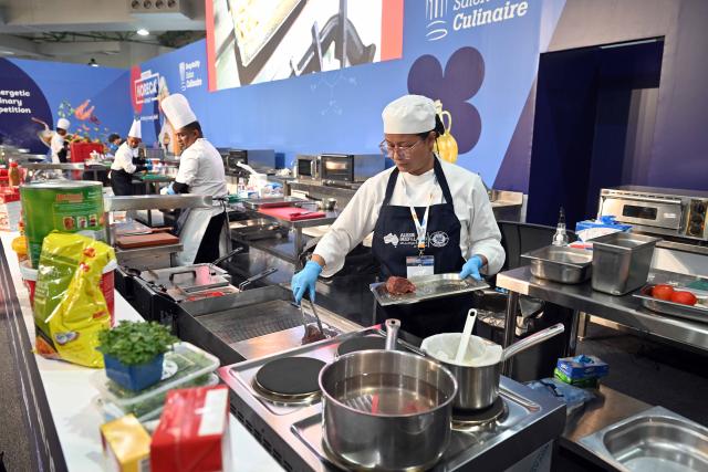 (260120) -- HAWALLI GOVERNORATE, Jan. 20, 2026 (Xinhua) -- A cook prepares food during the HORECA Kuwait 2026 exhibition in Hawalli Governorate, Kuwait, Jan. 19, 2026. The exhibition was launched here on Monday and will continue until Jan. 21.  HORECA is a combination of the words HO (hotels), RE (restaurants) and CA (cafes). (Photo by Asad/Xinhua)