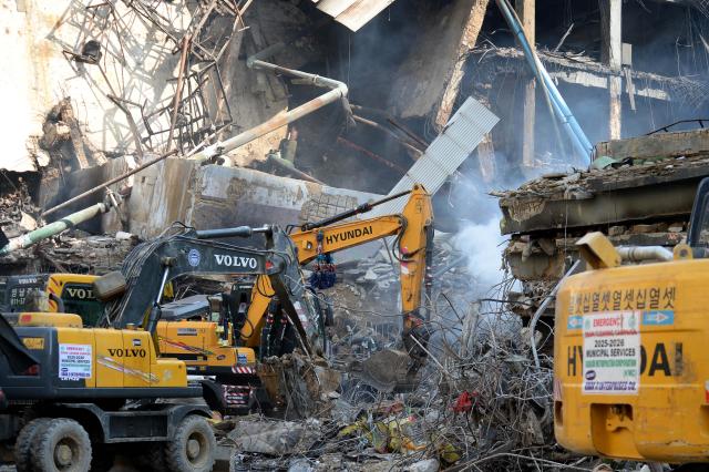 (260120) -- KARACHI, Jan. 20, 2026 (Xinhua) -- Rescuers use heavy machinery to remove debris at the fire site at a shopping mall in southern Pakistani port city of Karachi on Jan. 20, 2026. The death toll from a massive fire at a multi-storey commercial building in Pakistan's southern port city of Karachi has risen to 26, while 74 people are still missing, officials said on Tuesday. (Str/Xinhua)